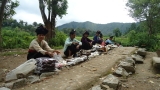 Phụ nữ Thái bán thảo dược bản địa bên lối đi vào khu di tích